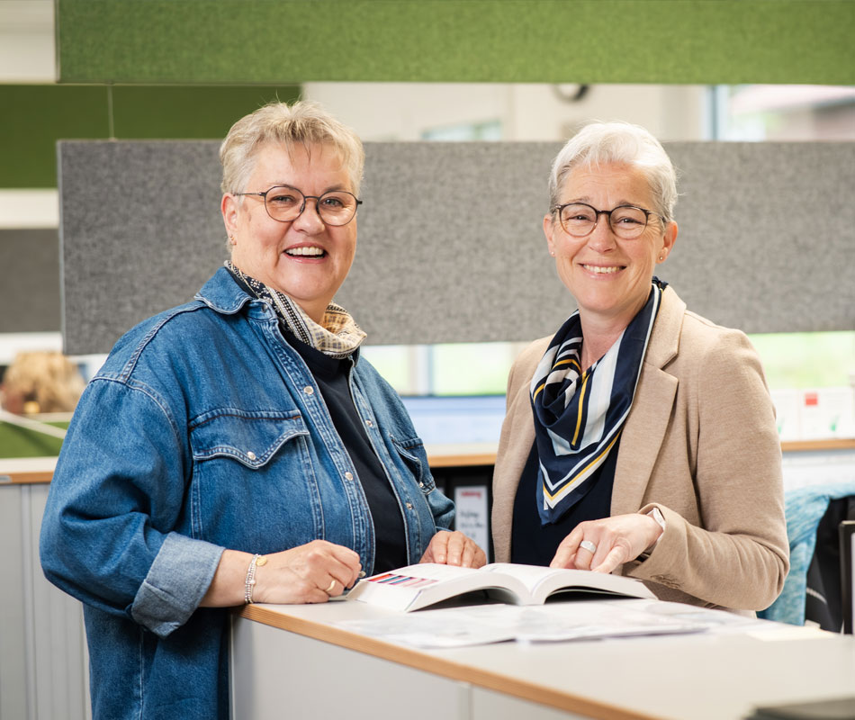 Sonja Sagowski und Silke Ötting im Büro mit dem Produktkatalog